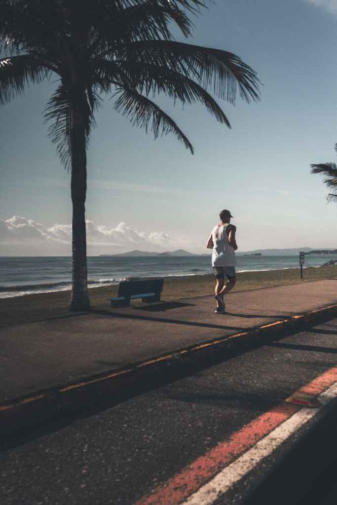 man wearing tank top near sea