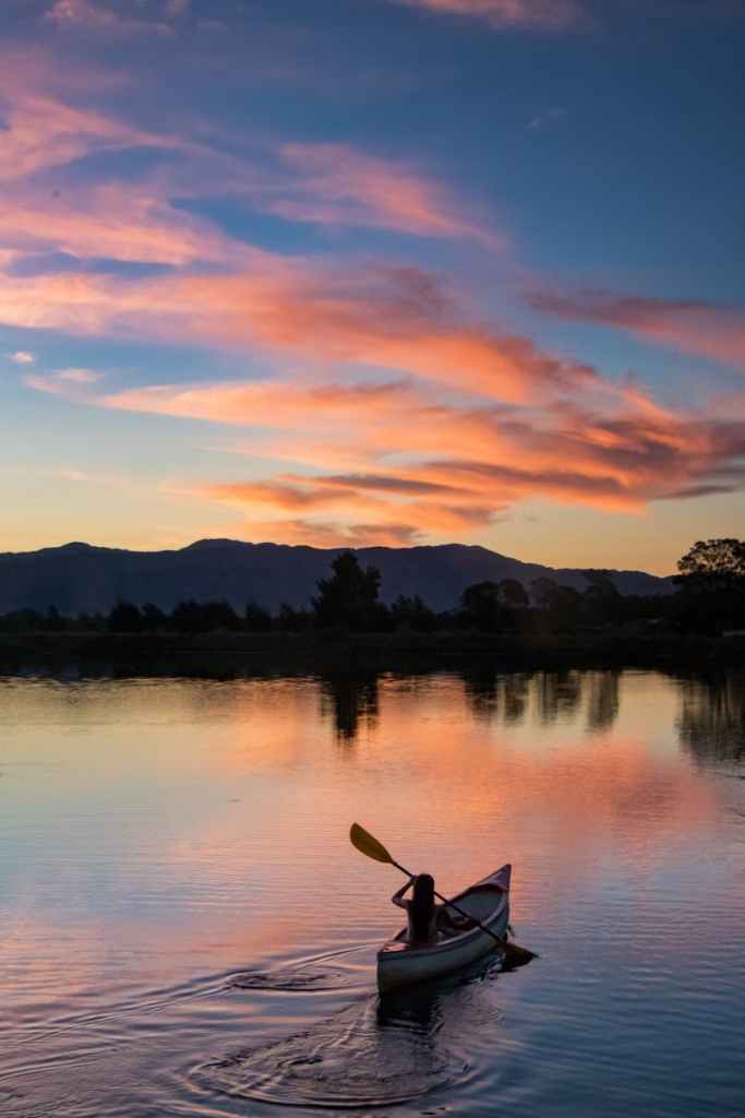 photo of person riding kayak during dawn