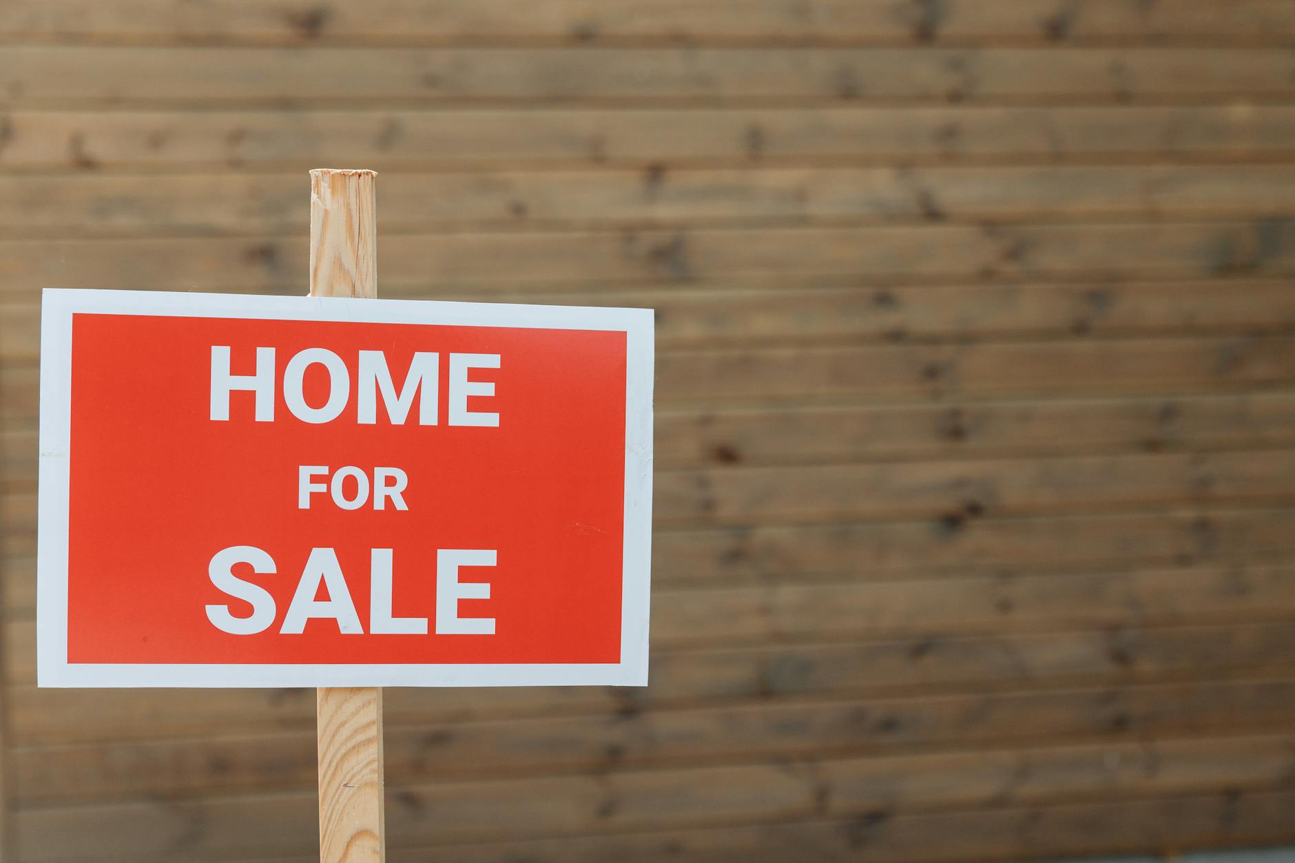 a close up shot of a sign of a house for sale