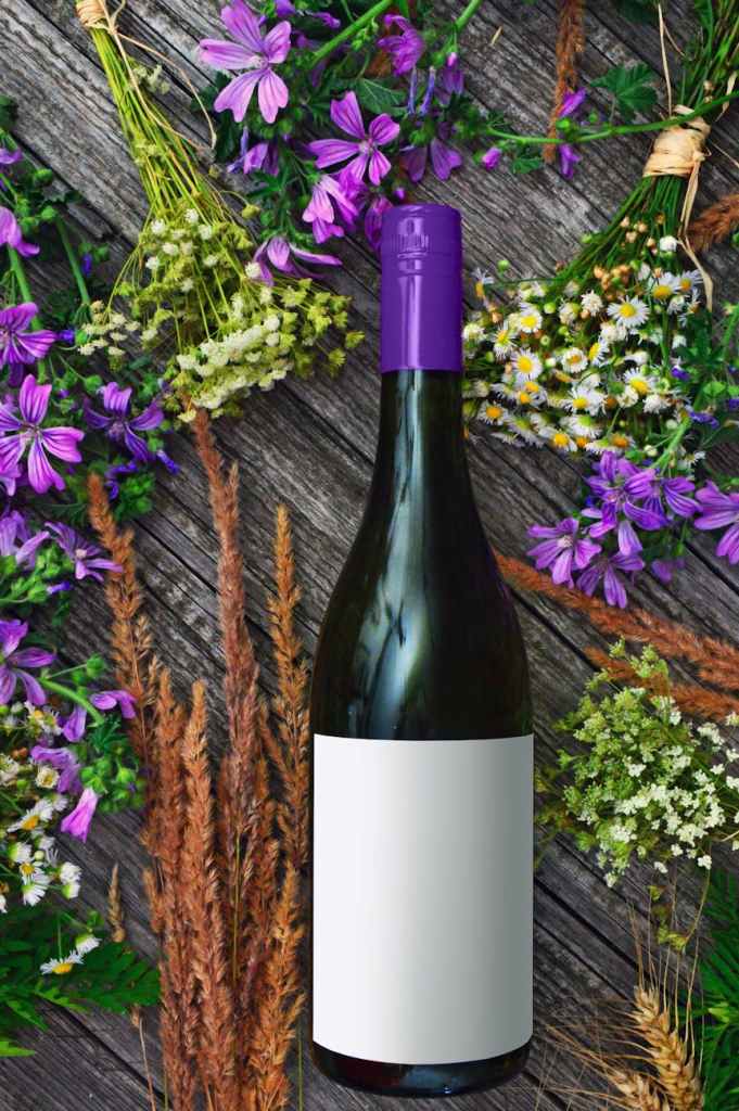 photo of wine bottles near flowers