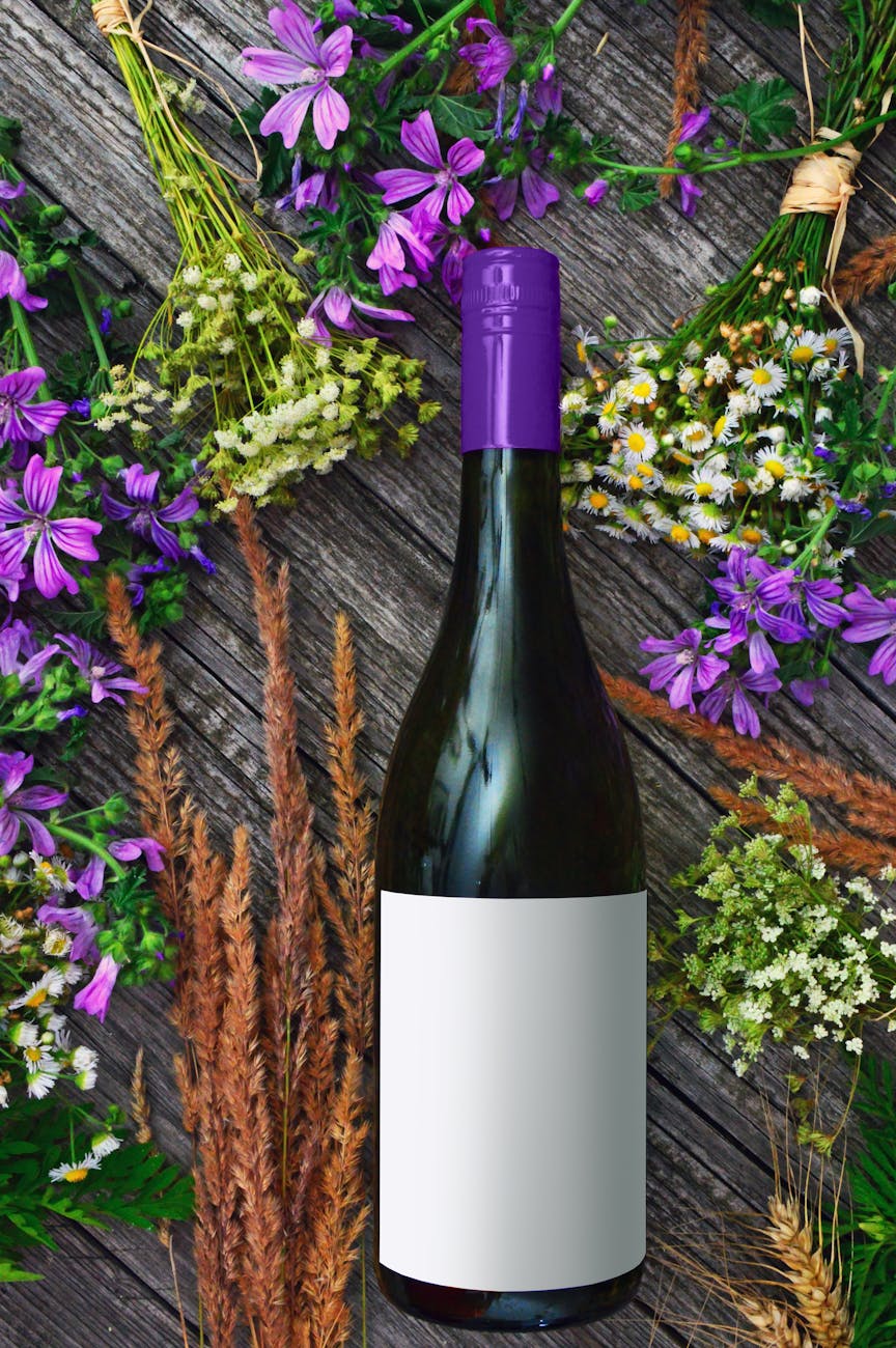 photo of wine bottles near flowers