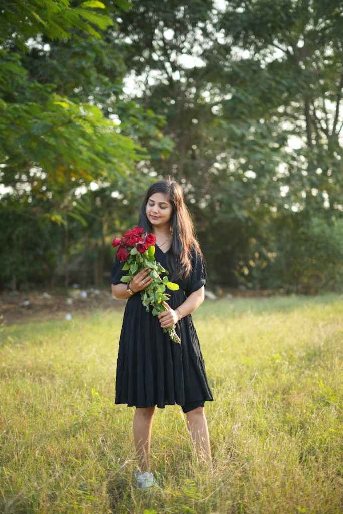 young woman holding flowers in a sunny meadow