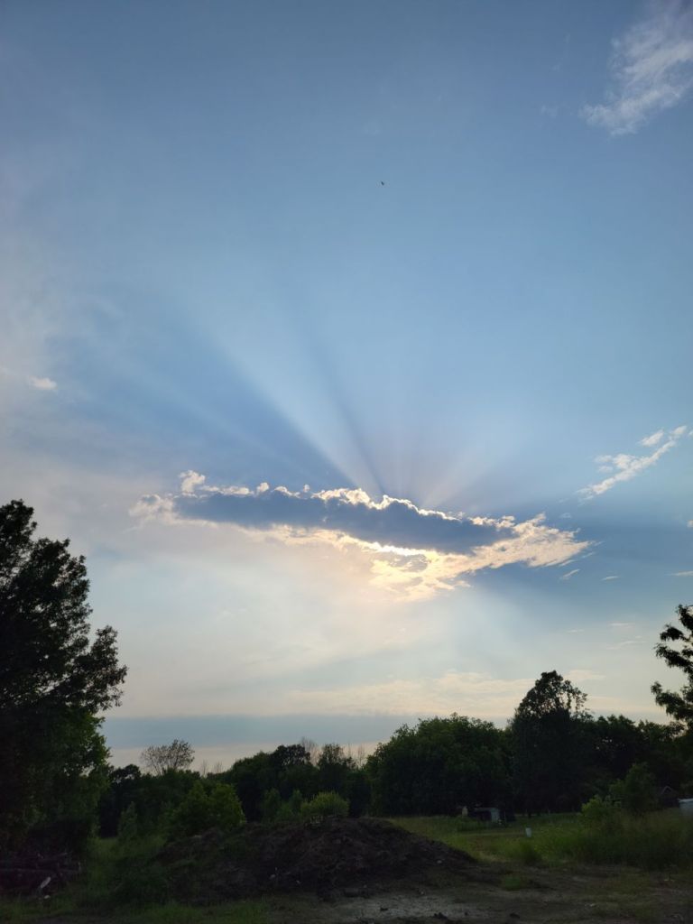 sun hiding behind the clouds in the sky
