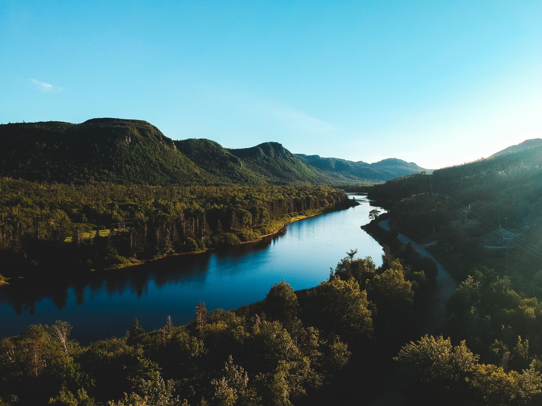 clear sky over river and slopes in valley
